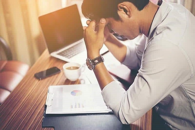 Stop procrastinating- man thinking on desk